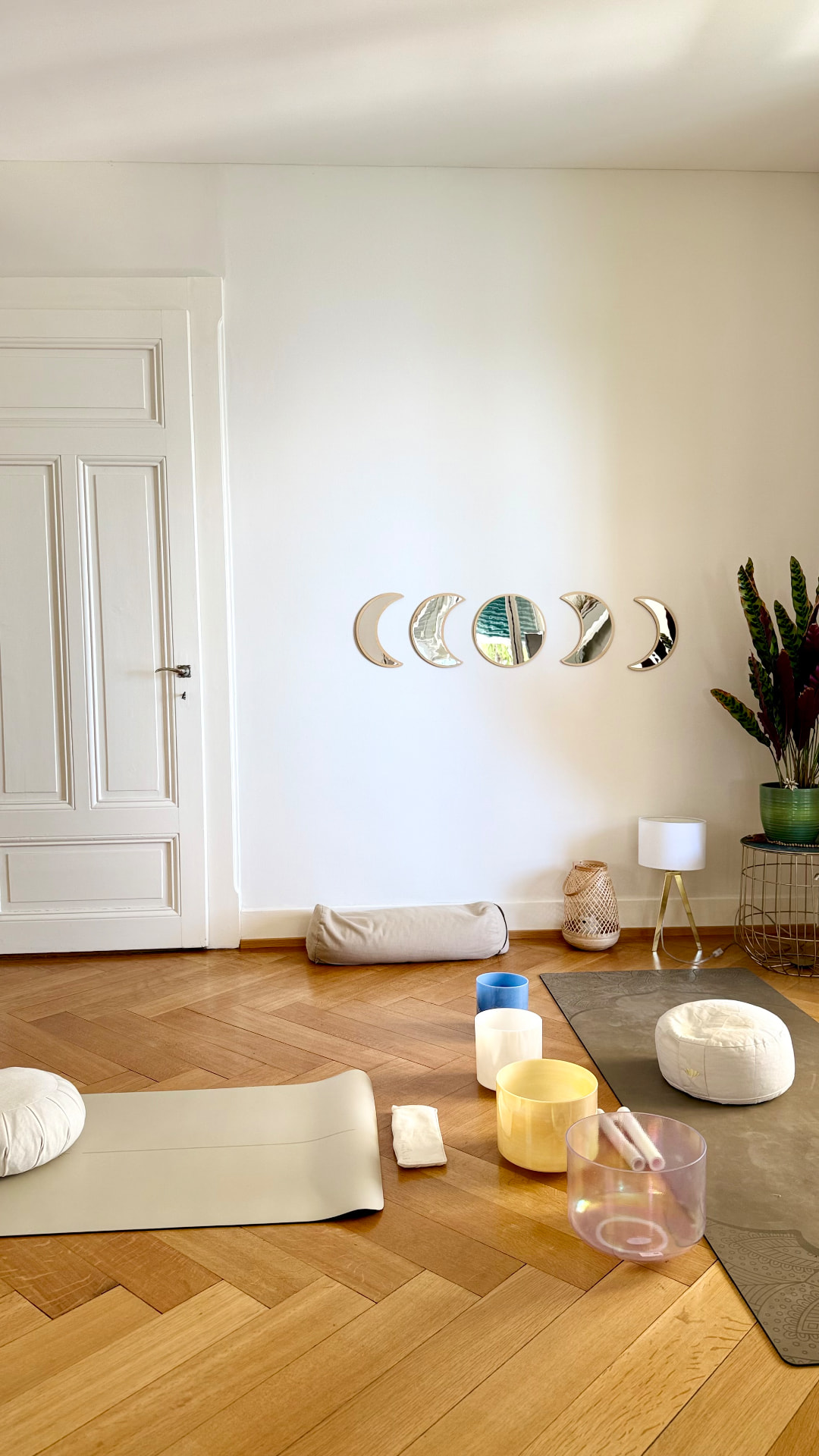 The studio with moon phase mirrors, mats and crystal singing bowls on herringbone parquet